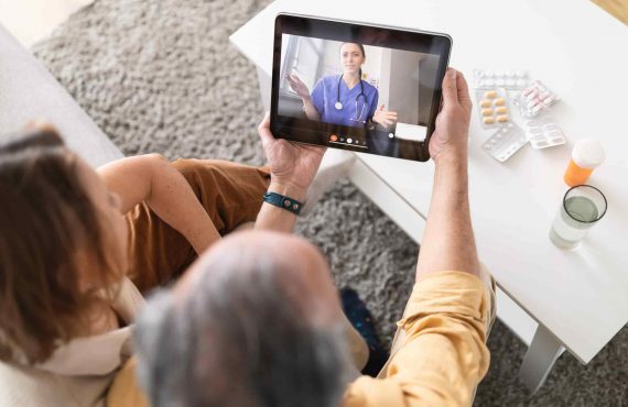 Using telemedicine services at home. Senior couple using digital tablet having video call with online doctor