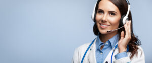 happy smiling doctor in headset, on grey