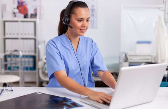 Medical receptionist wearing headset with microphone in private hospital