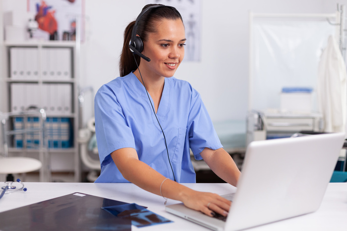 Medical receptionist wearing headset with microphone in private hospital