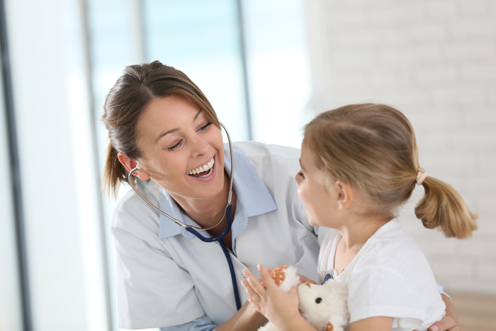 Doctor examining little girl with stethoscope