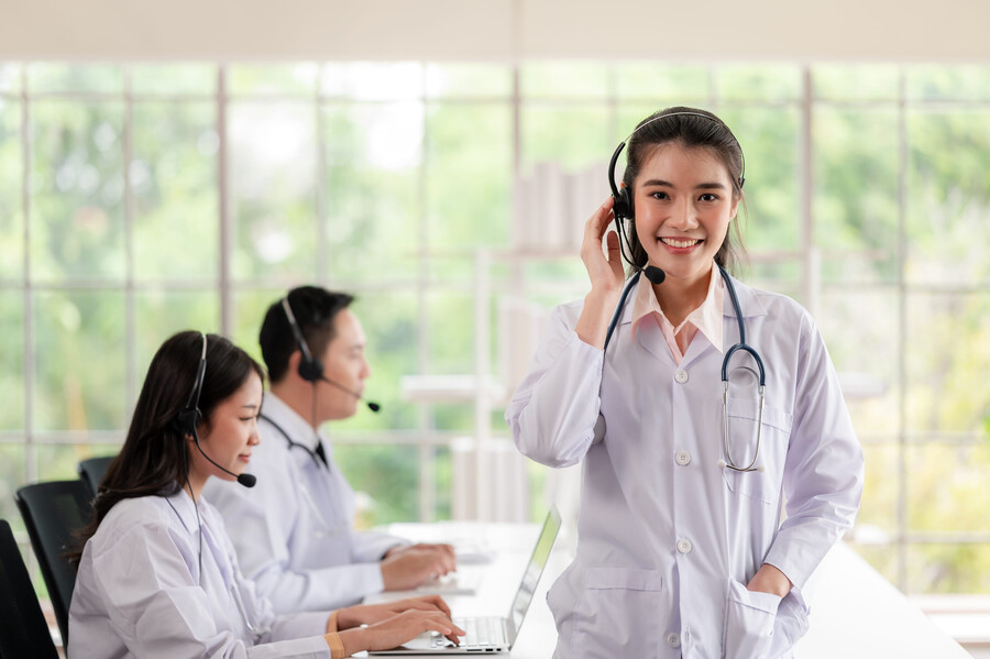 medical call answering experts on call, one expert standing smiling at the camera
